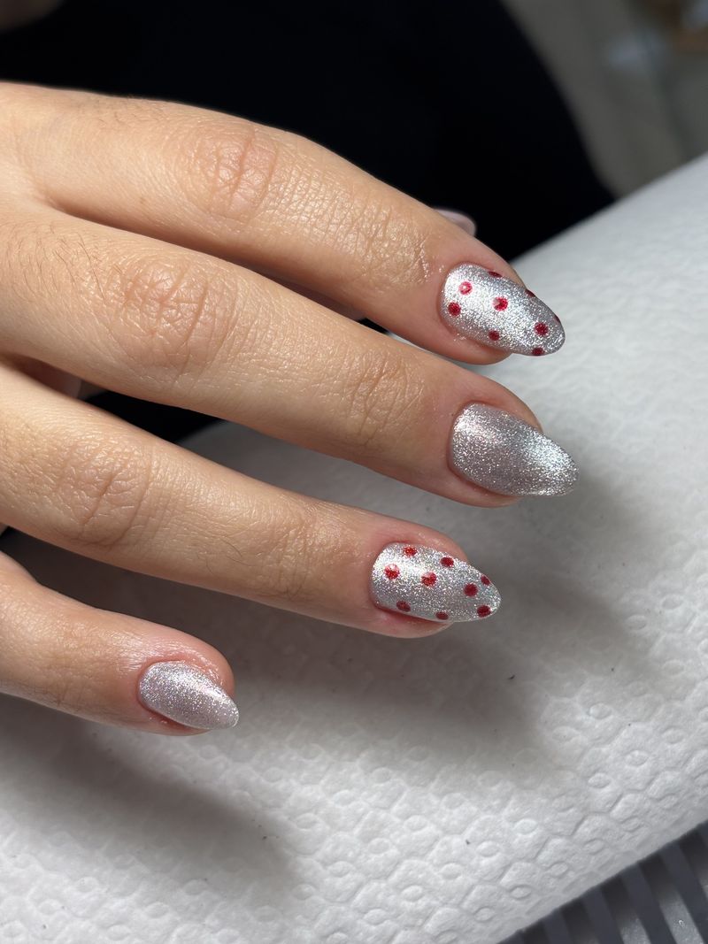 Unhas amendoadas com glitter prateado e bolinhas vermelhas pintadas à mão