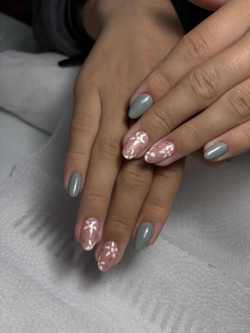 Unhas alternando cinza e nude com flores brancas pintadas à mão