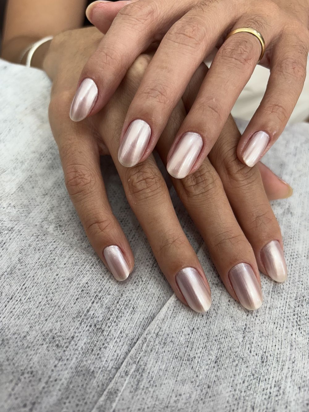 Unhas amendoadas compridas em nude com efeito cromado e anel dourado